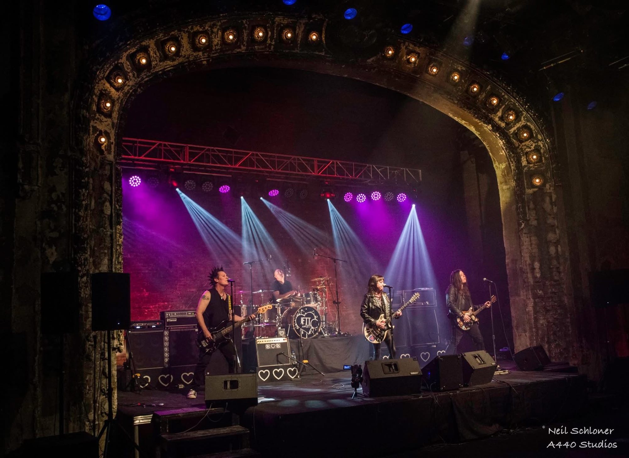 Four-piece band performing on a historic theatre stage