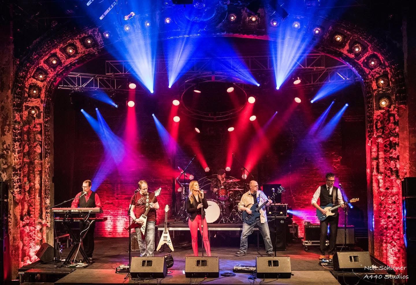 Band on stage lit in red and blue